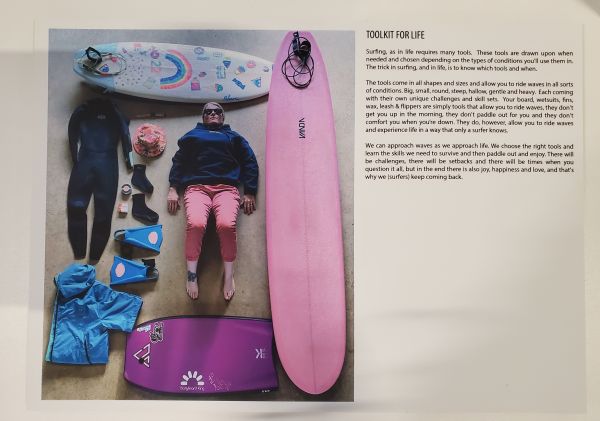 woman lies down surrounding by surfing gear