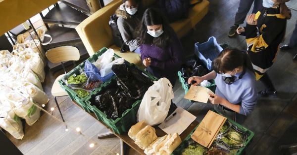 Overhead top down view of two women packing food boxes
