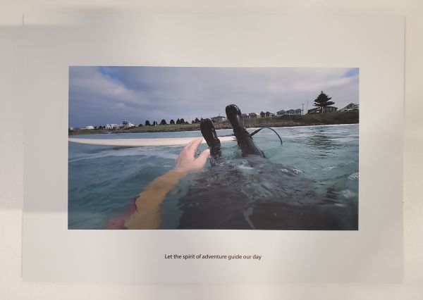 photo of someone's feet in the ocean in a wetsuit
