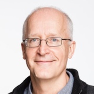 Image of man wearing glasses with short grey hair in front of white backdrop