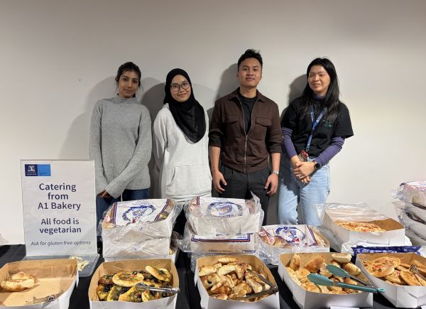 4 Ambassadors behind table with food