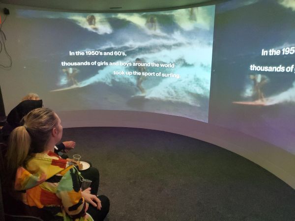 people sat in immersive room watching documentar