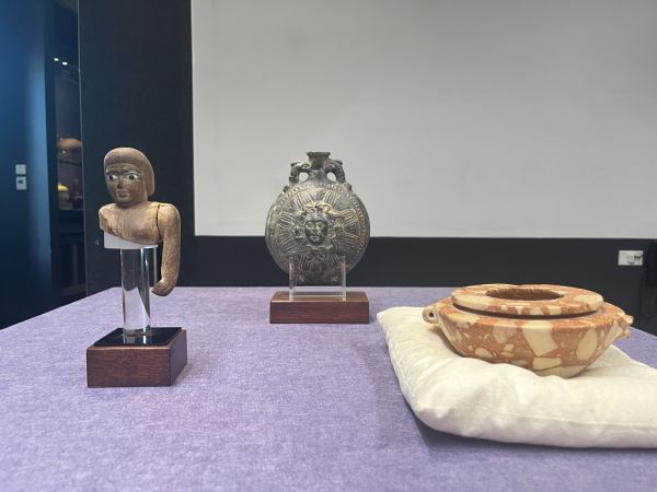 Collection of ancient wooden, bronze, and marble artefacts on exhibition.