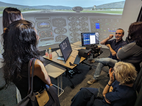Group of people with instructor in a cockpit simulator room