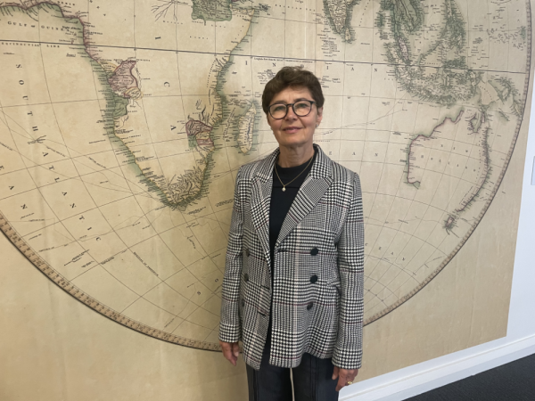 Associate Professor Galyna Piskorska in front of world map