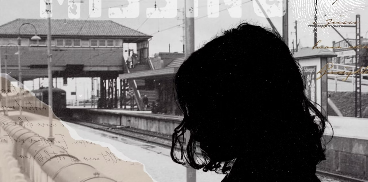 A person standing in front of a train station