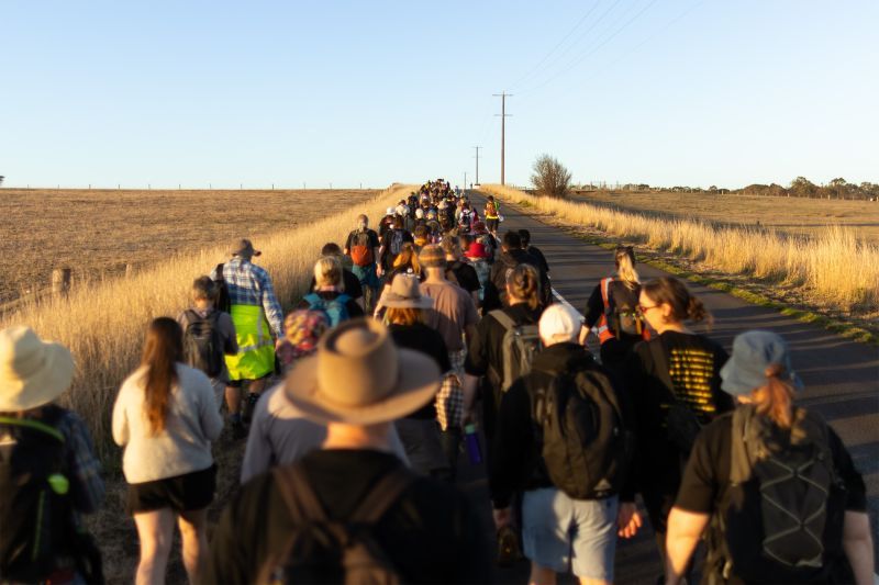 A group of people walk along a road