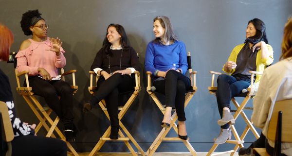 A panel of women speakers on director's chairs is pictured.