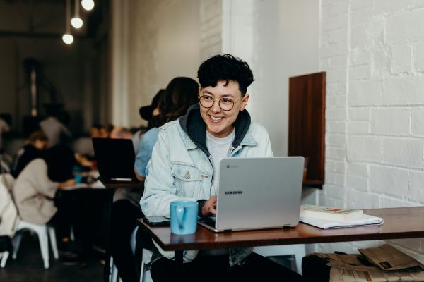 Male sitting in front of laptop smiling