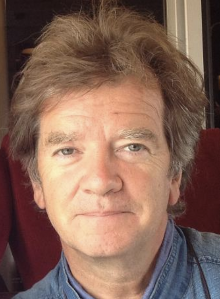 Face of Richard Kearney with white skin, brown and grey hair and blue eyes