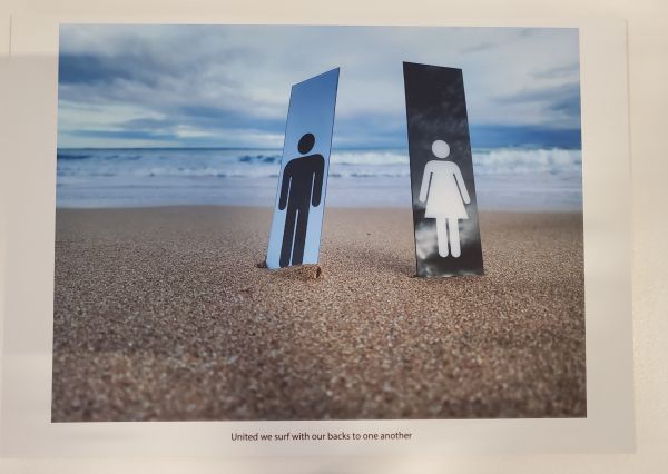black and white symbols for man and woman stuck into sand