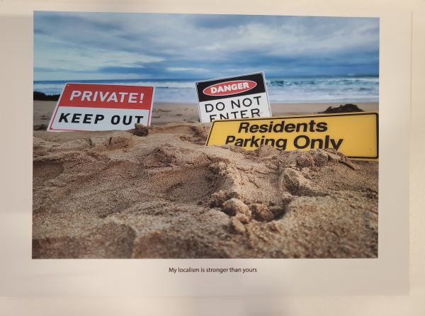 signs planted into sand on beach that say keep out, do not enter, residents parking only