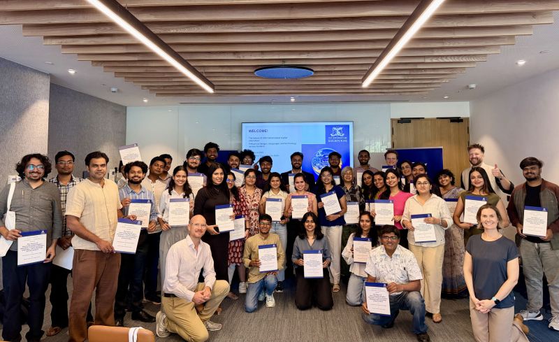 A group of people look toward the camera each are holding a certificate.