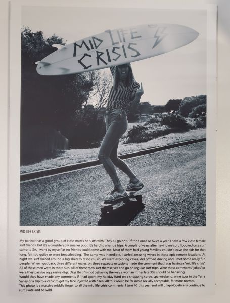 woman on skaetboard holding a surboard that reads midlife crisis