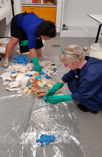 Two people wearing PPE sorting conservation lab waste