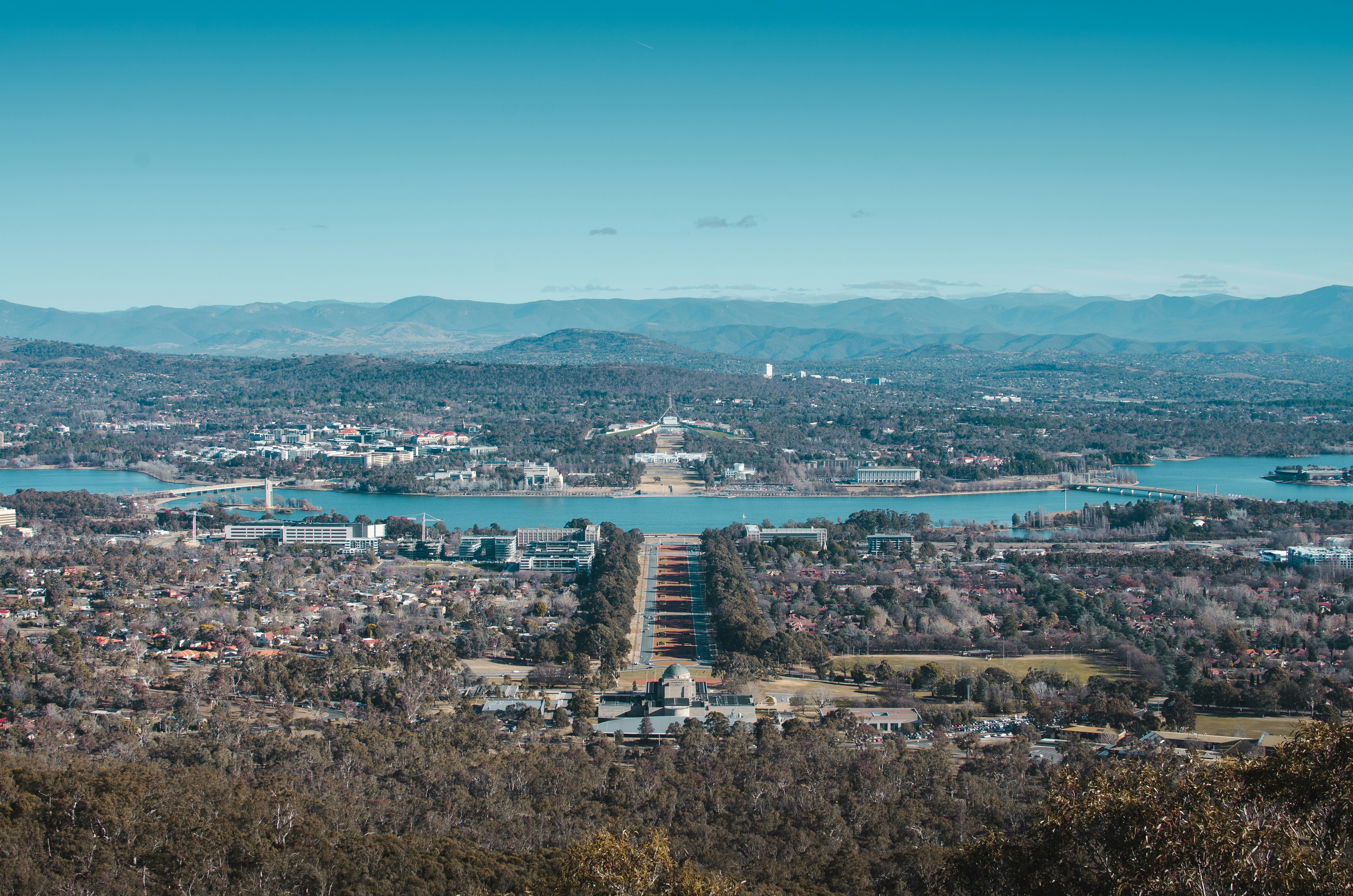 Canberra cityscape featuring mountains, trees, and blue sky
