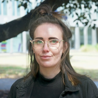 Woman wearing glasses with a park in the background