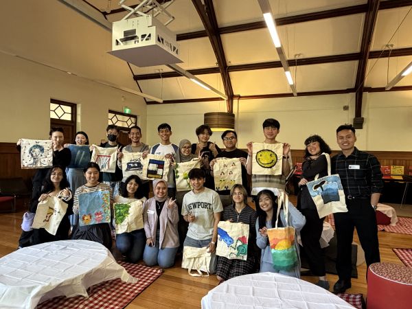 Group of students gathered, holding self-made artworks