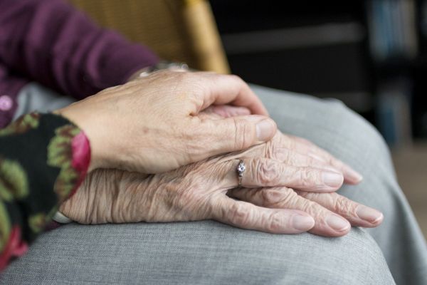 Carers hand on old persons hand